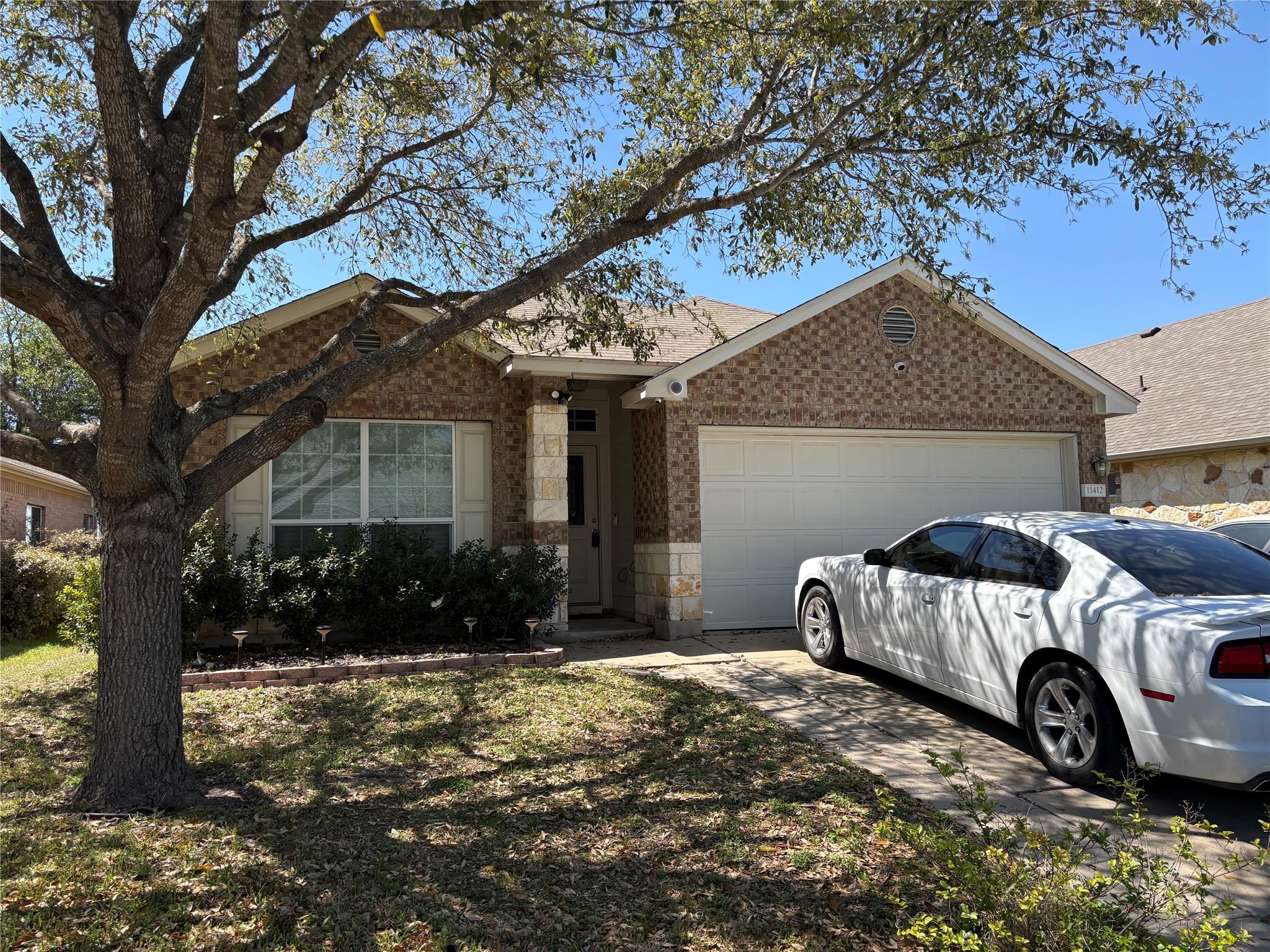 Ranch-style house featuring brick siding, an atta