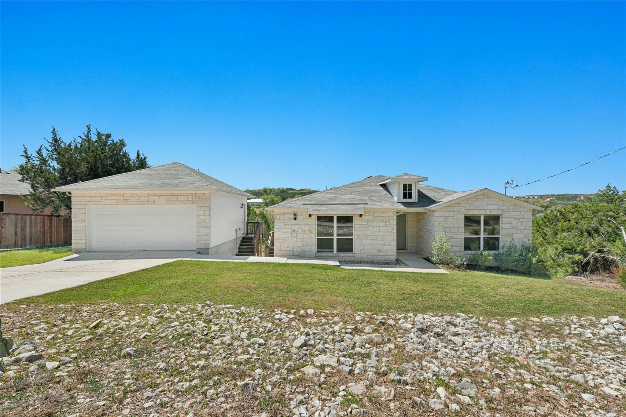 Ranch-style house featuring a front yard, a garag