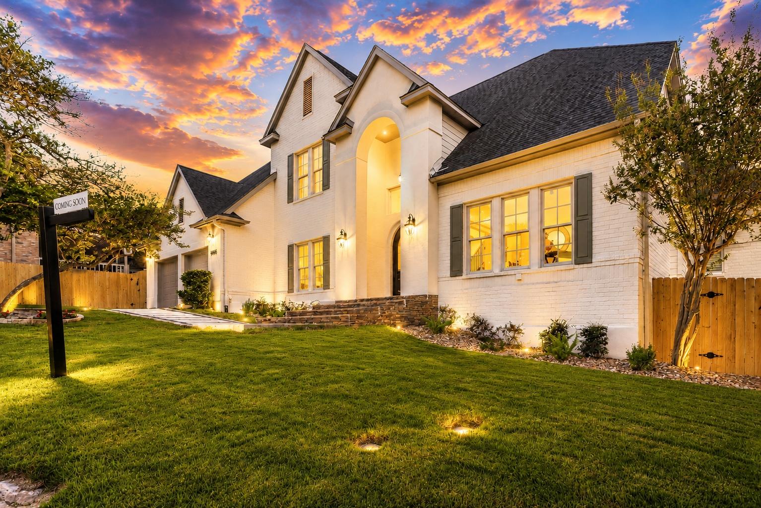 Elegant brick and siding facade with lush landsca