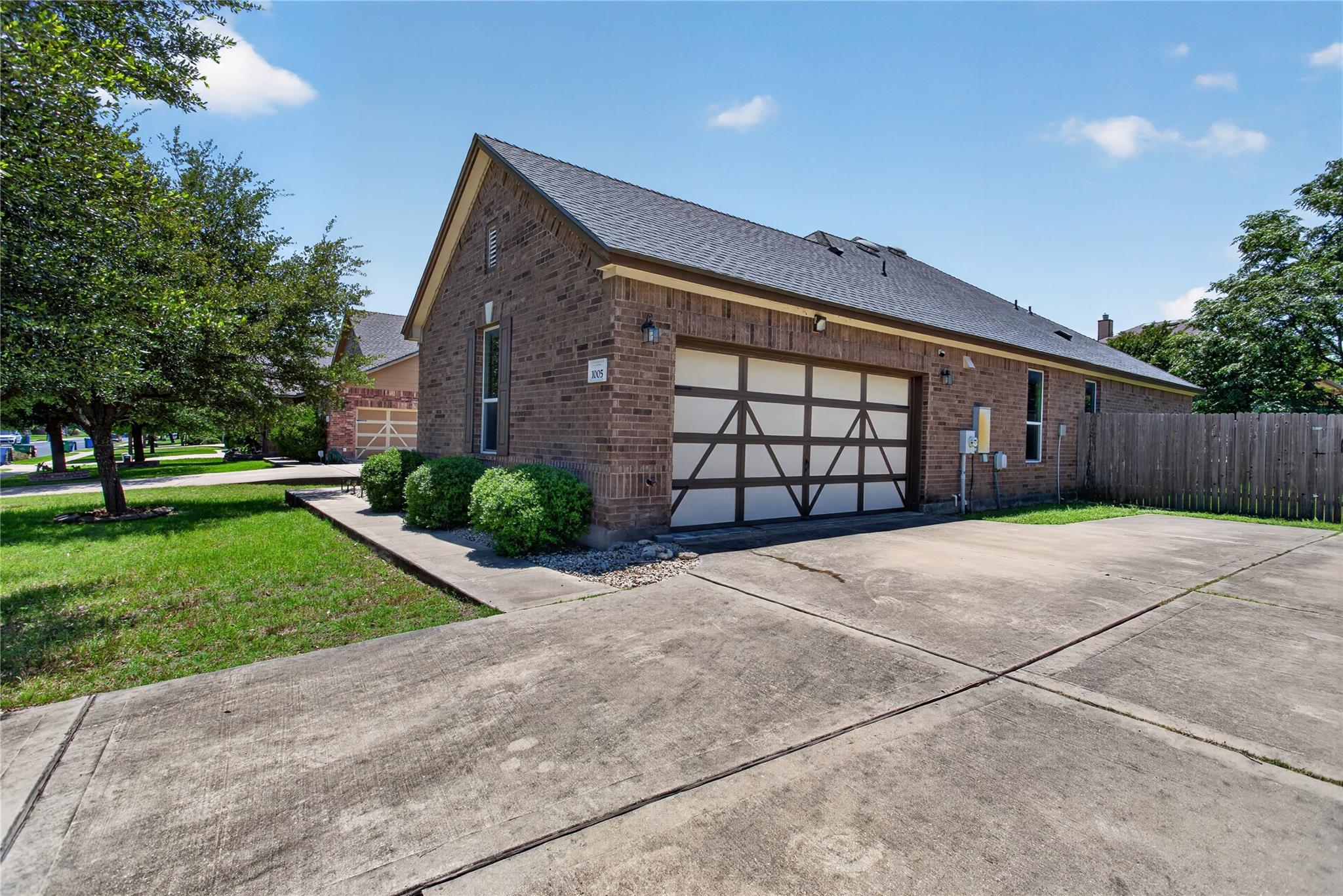 Brick exterior featuring a two-car garage with de