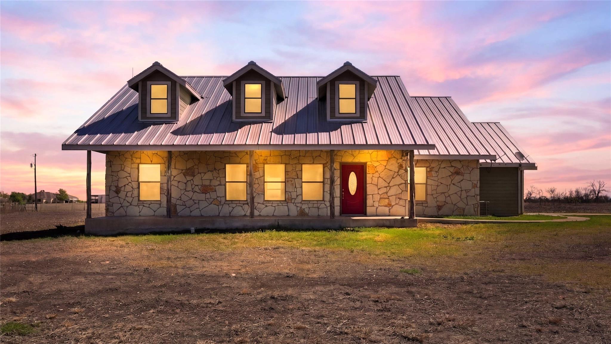 View of front facade featuring stone siding, a me