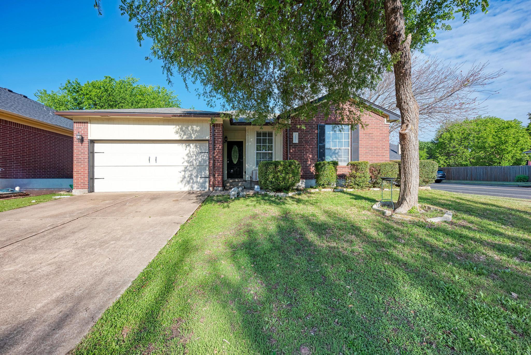 Ranch-style house featuring brick siding, an atta