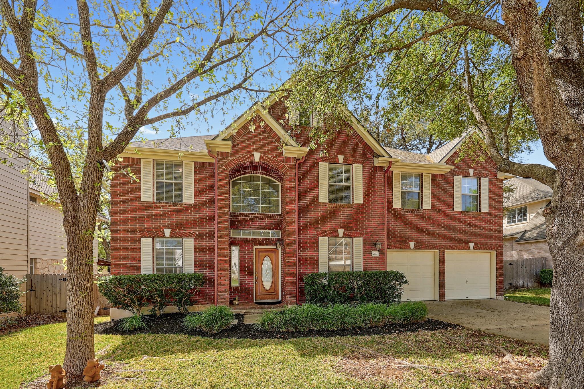Traditional home featuring a garage, driveway, an