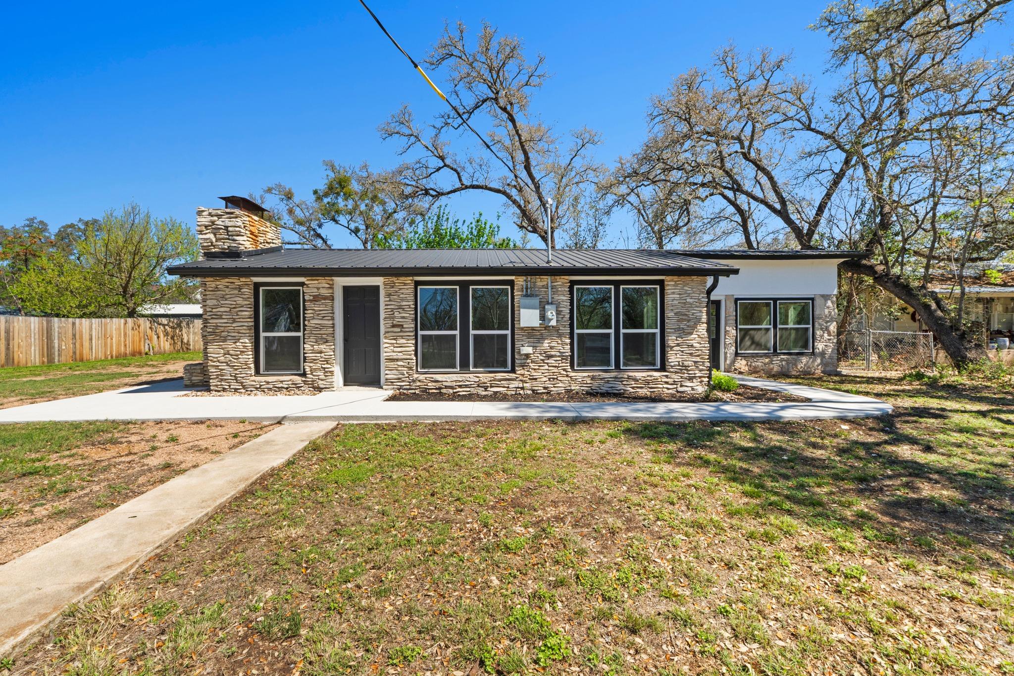 Mid-century inspired home with stone siding, a ch
