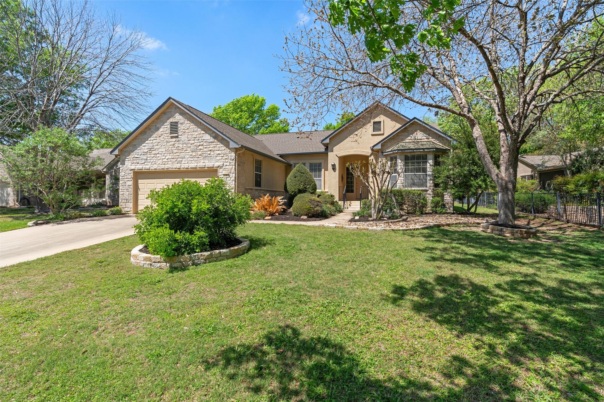 Ranch-style home featuring stone siding, a garage