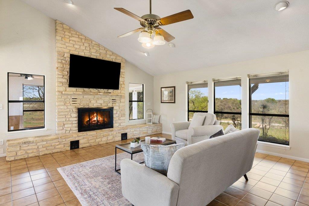 Living room with ceiling fan, light tile patterne