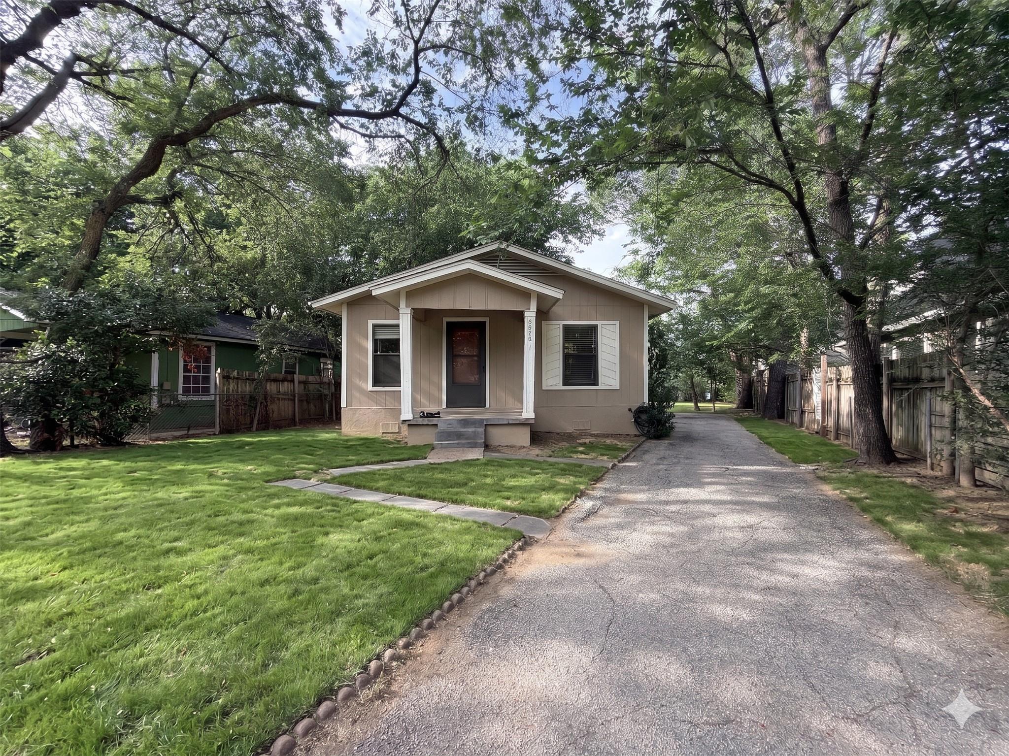 A welcoming front facade with a long driveway and