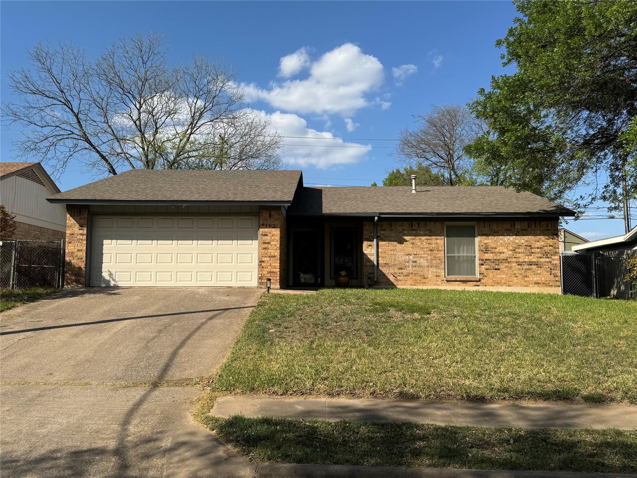 Ranch-style house with a garage, a shingled roof,
