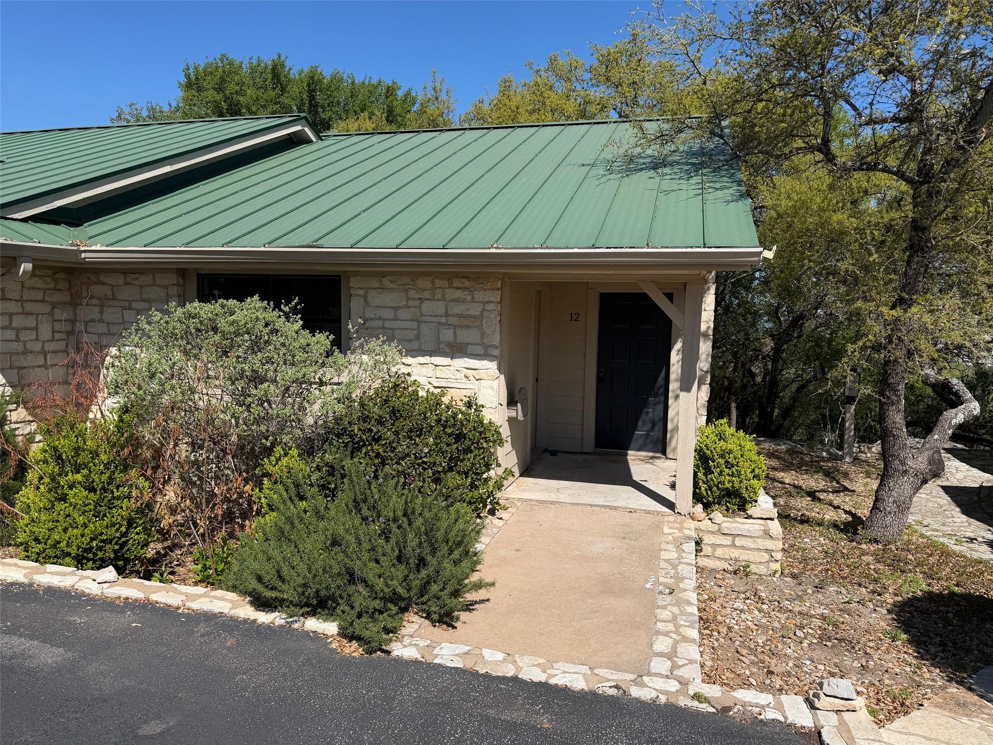Property entrance with stone siding and a standin