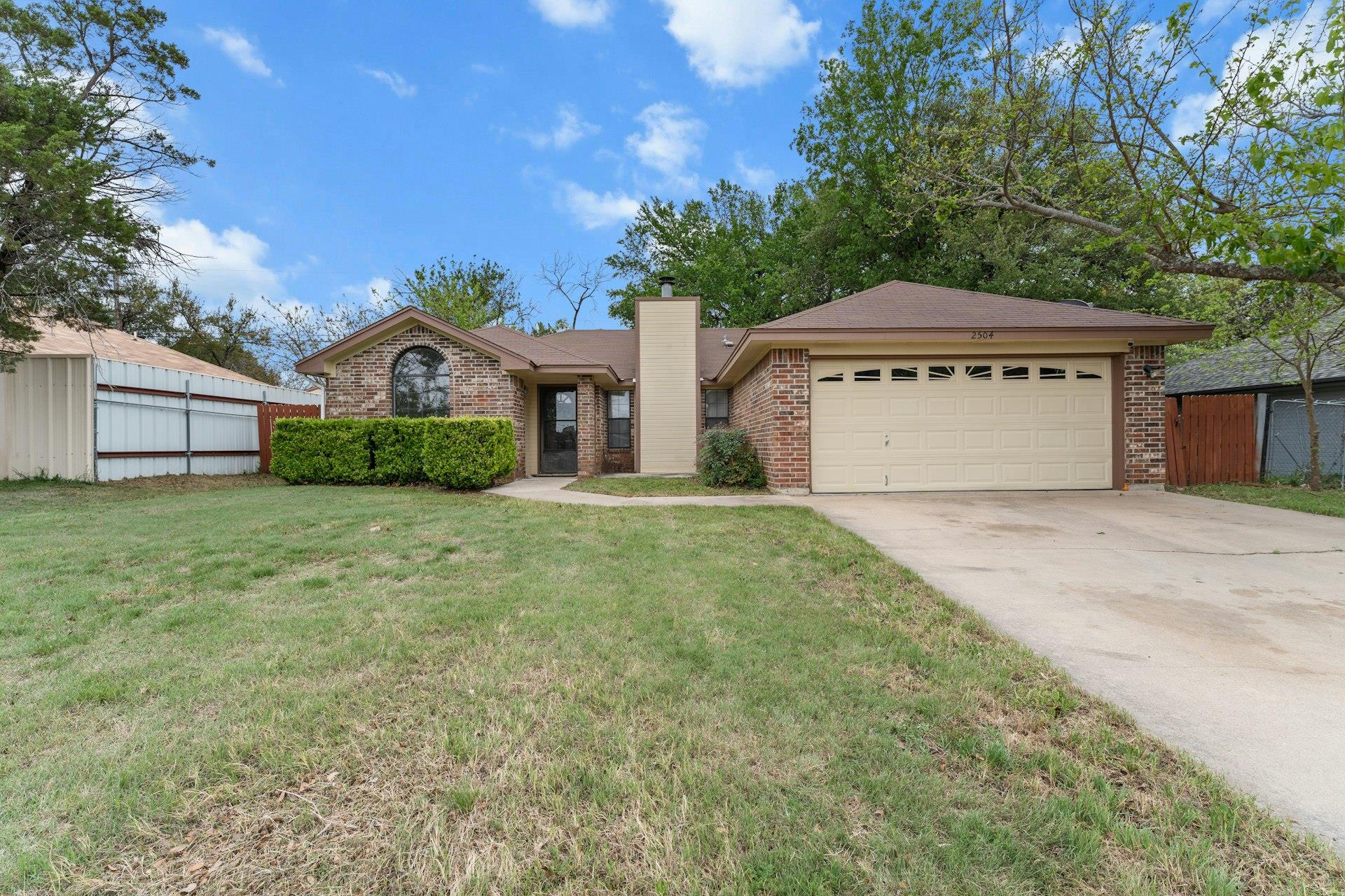 Ranch-style house featuring a garage, brick sidin