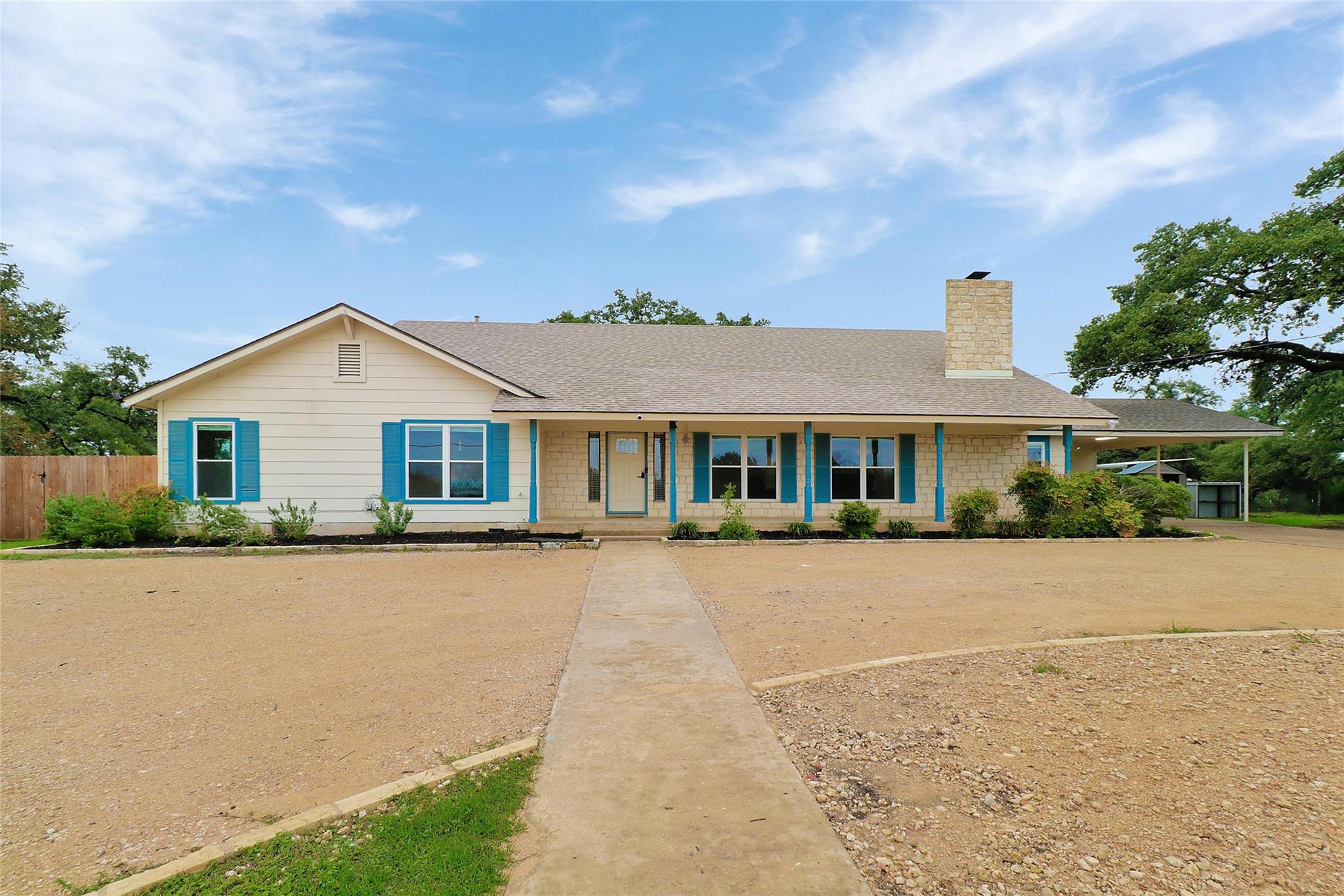 Ranch-style home featuring covered porch, a chimn