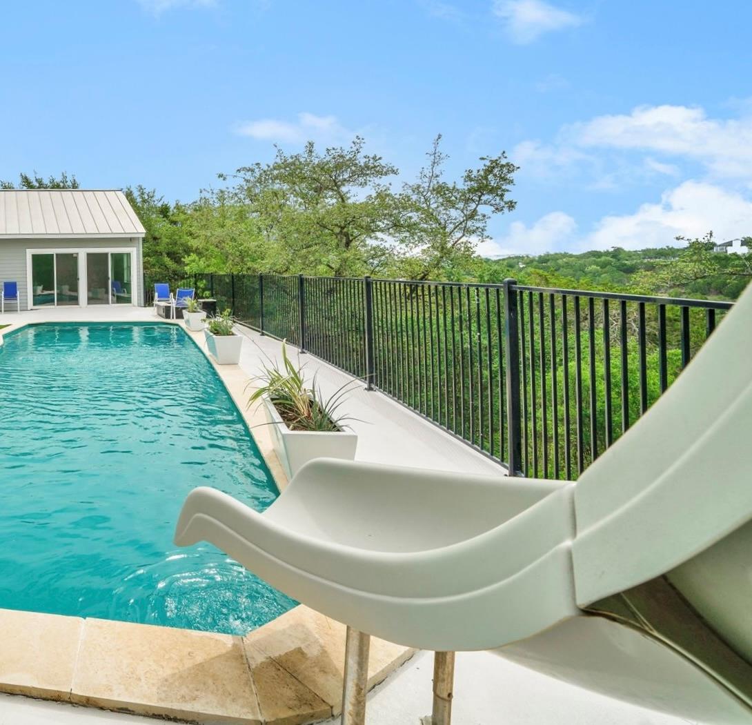 A tranquil swimming pool with a slide overlooks a