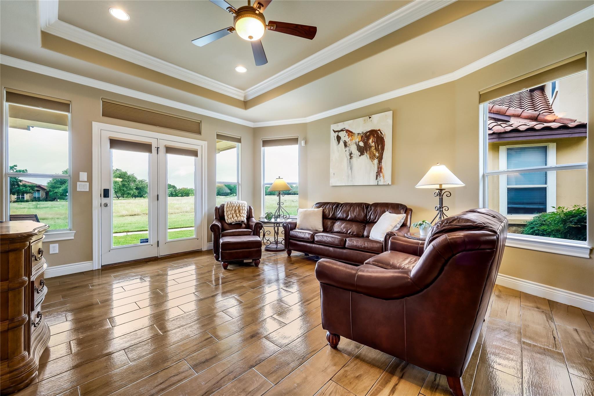 Living area featuring wood-finish flooring, a tra
