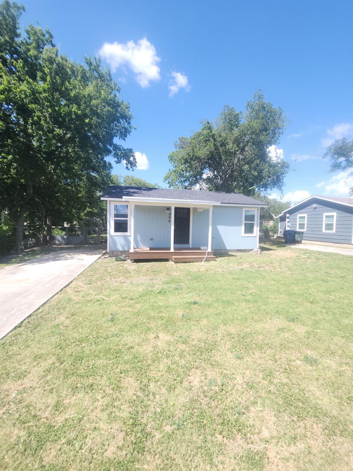 Single story home with a front lawn, a porch, and
