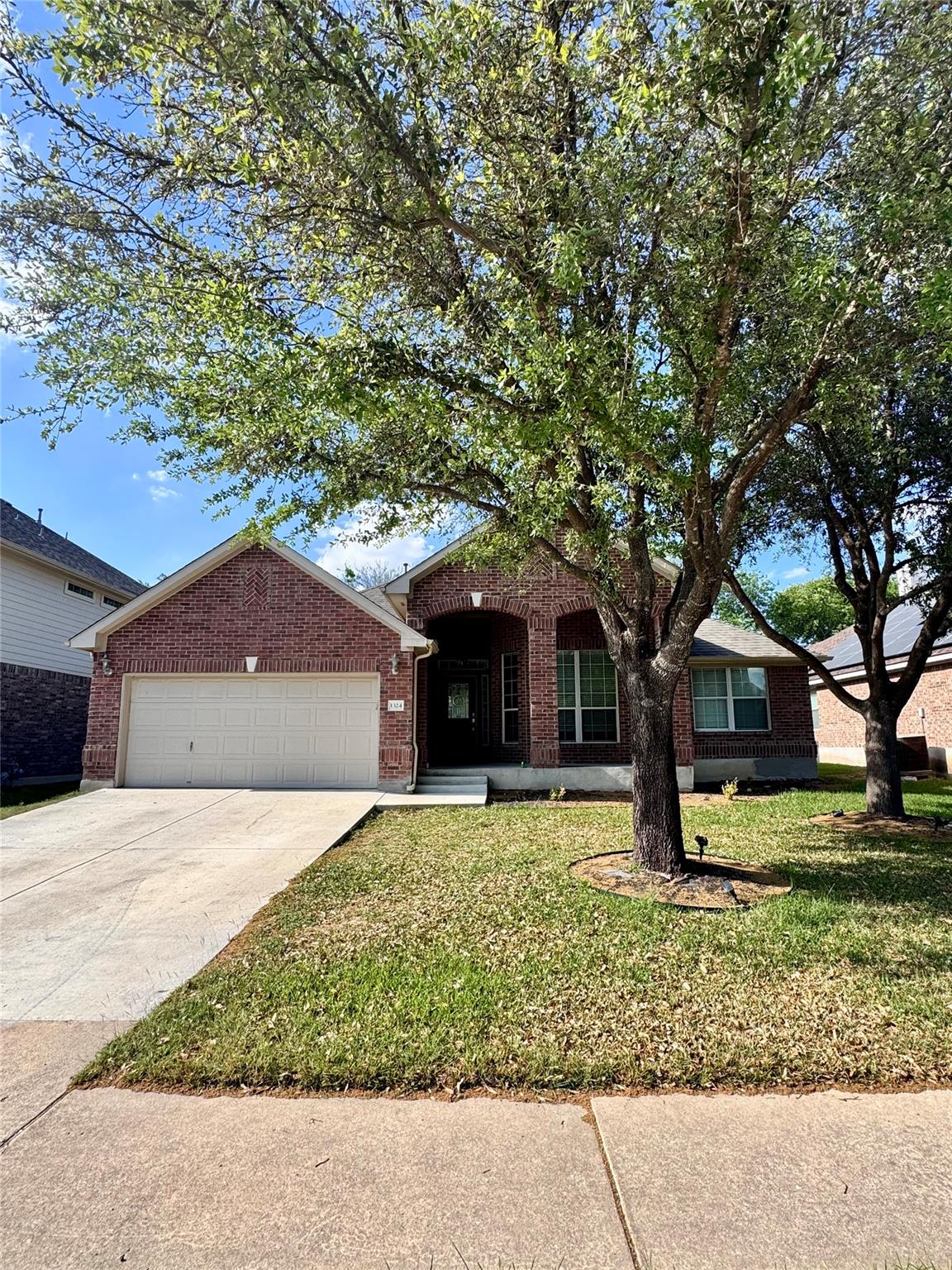 Ranch-style home with a garage, driveway, a front