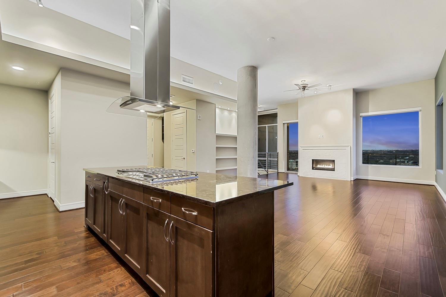 Kitchen with dark wood finish cabinetry, island e
