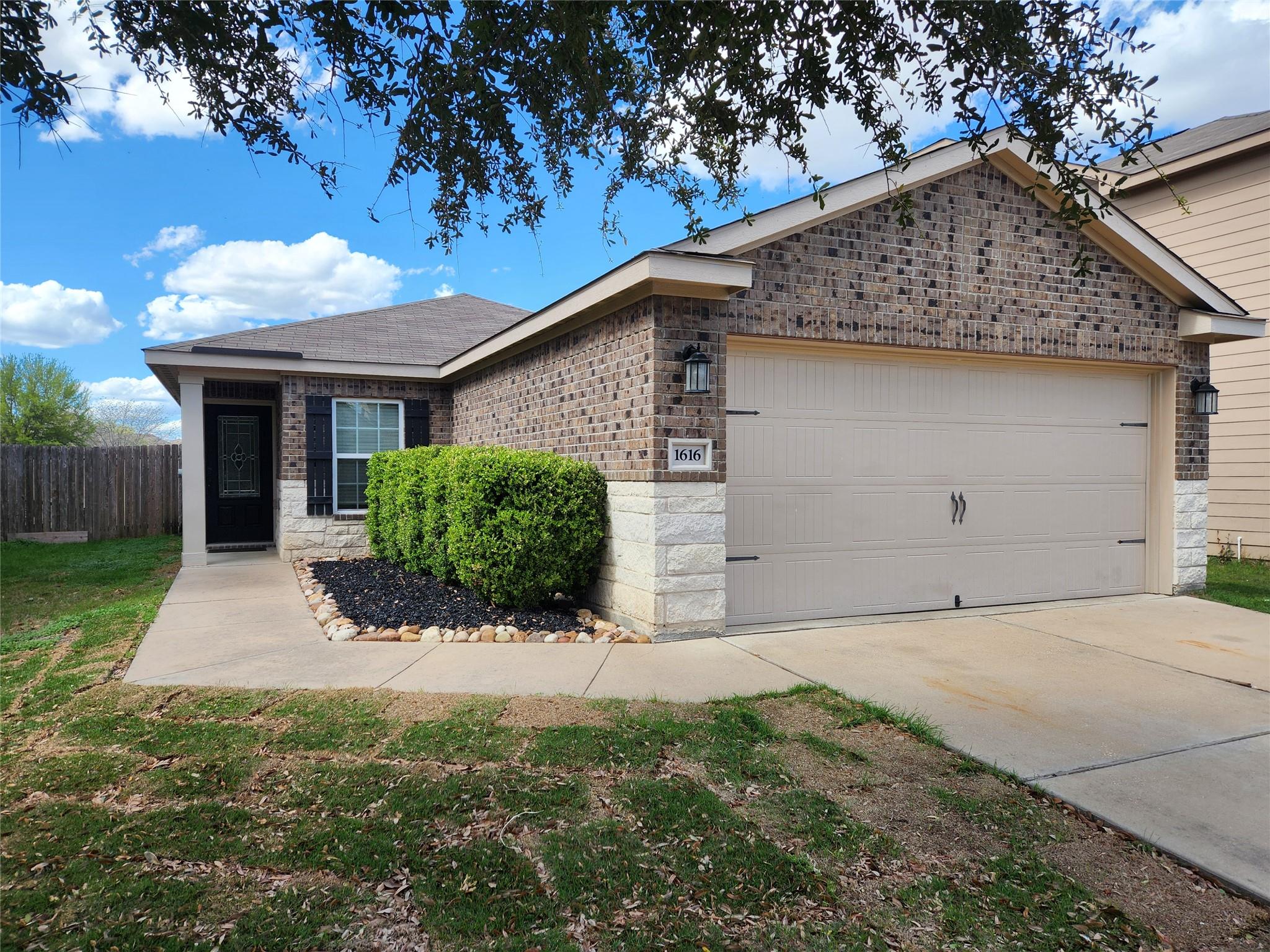 Ranch-style house with a garage, driveway, and br