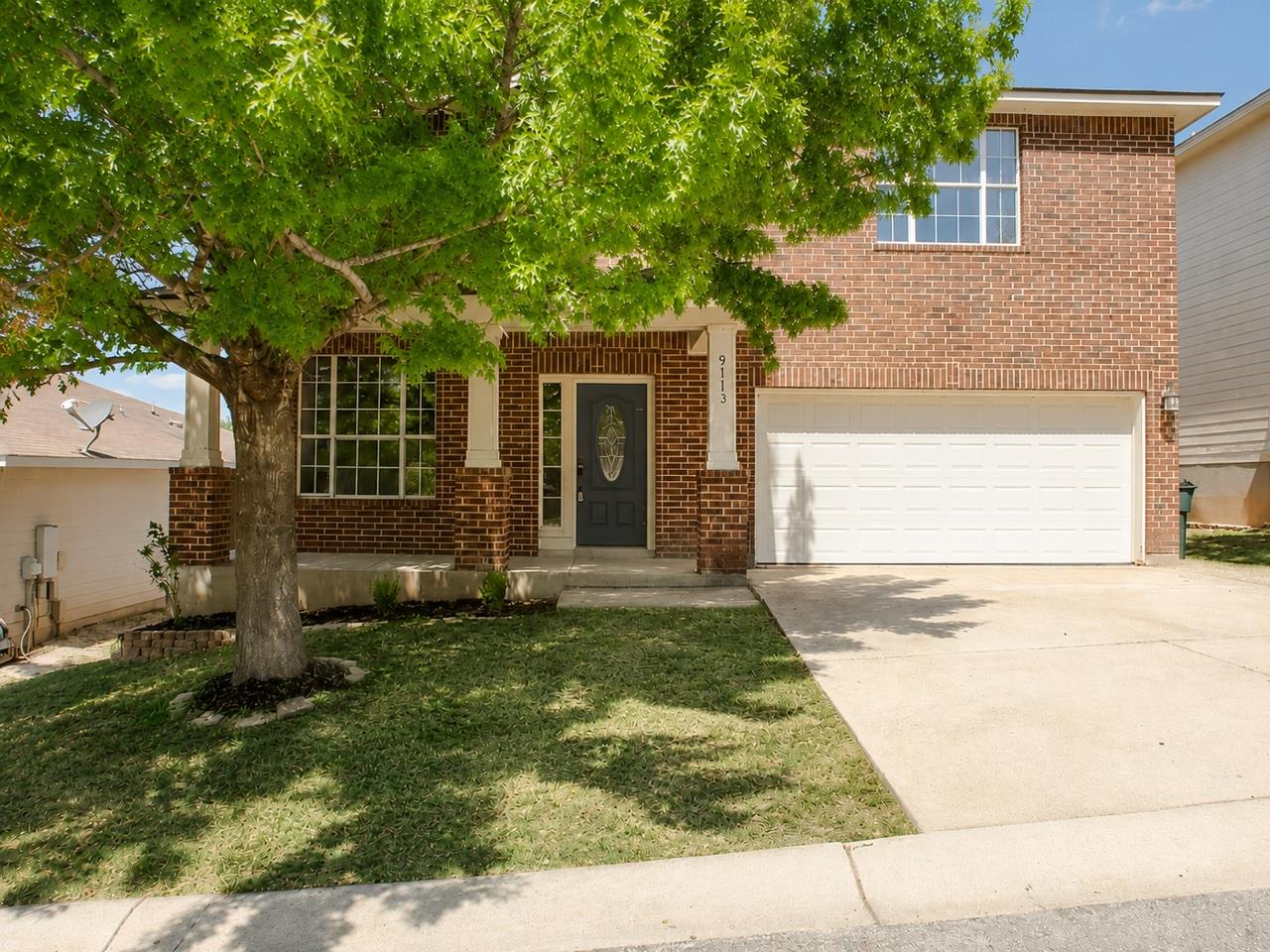 Mature shade trees and timeless brick construct a