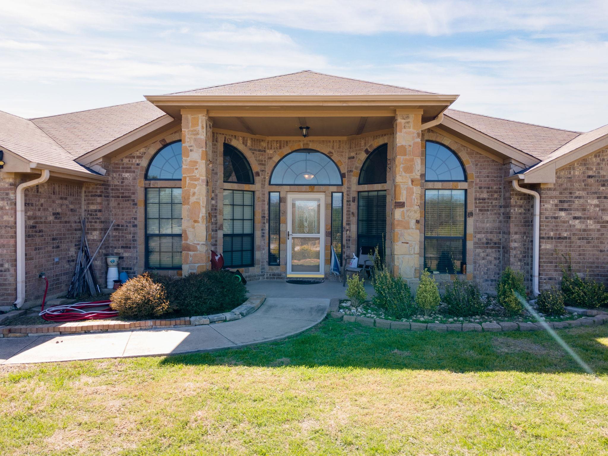 Entrance to property featuring brick siding, a ya