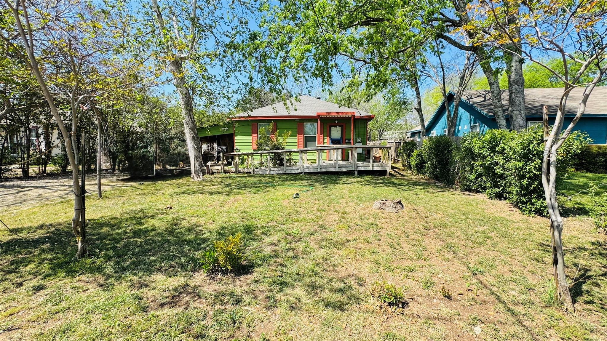 Rear view of house featuring a lawn and a deck