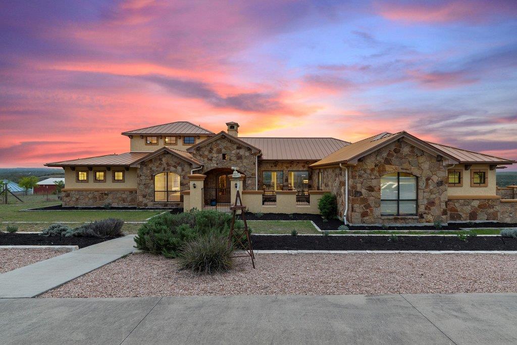 View of front of home with stone siding, a standi