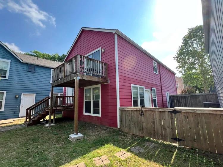 Rear view of property with a wooden deck and stai