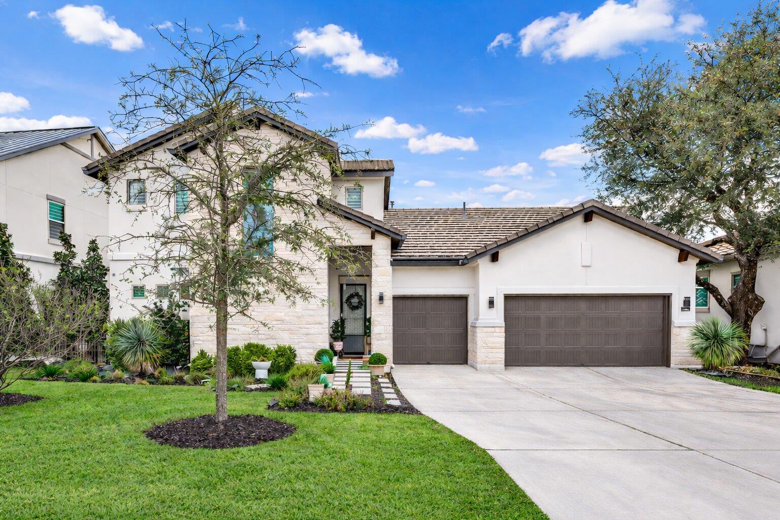 View of front of home featuring stone siding, a g