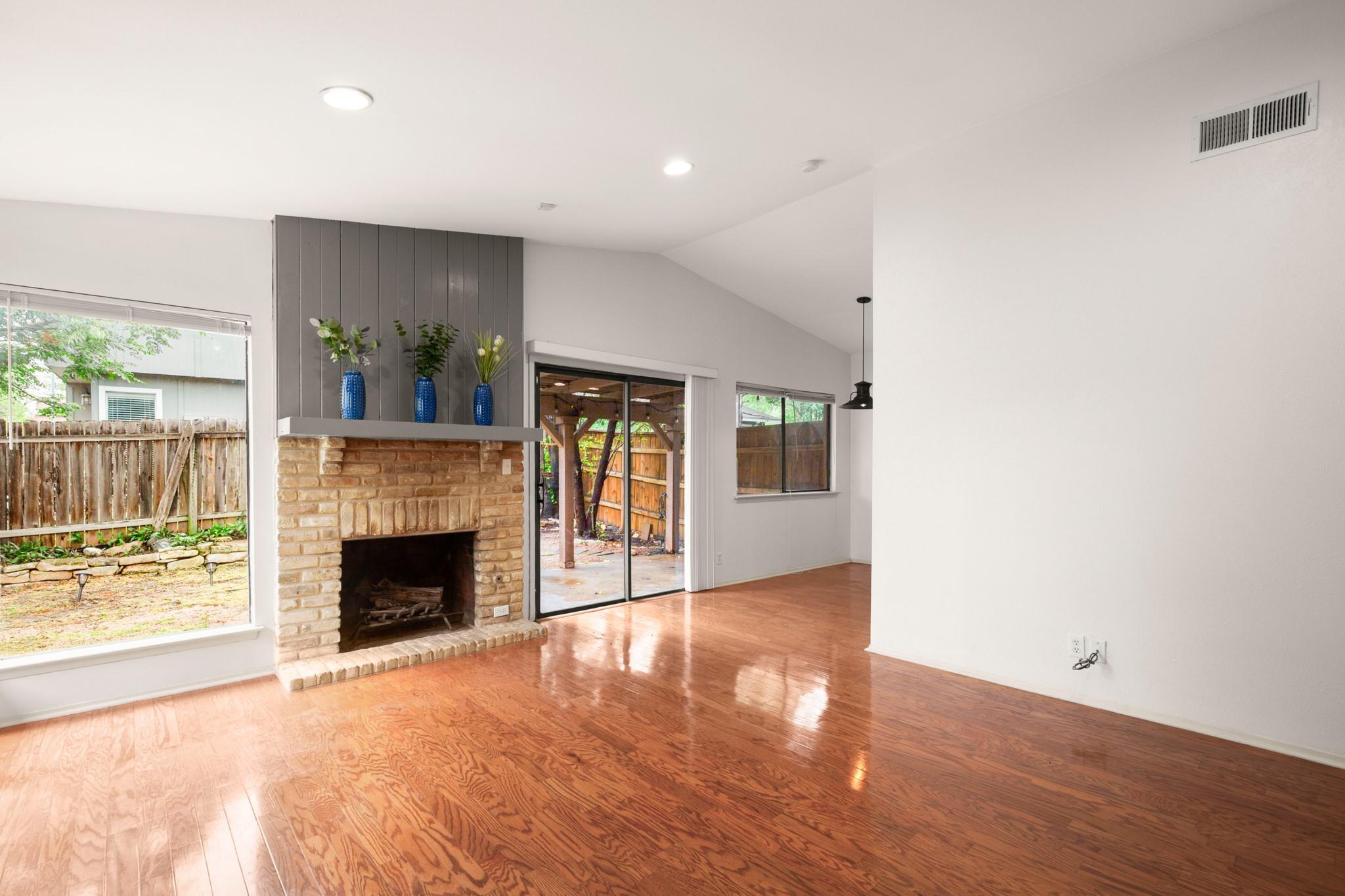 Unfurnished living room with lofted ceiling, ligh