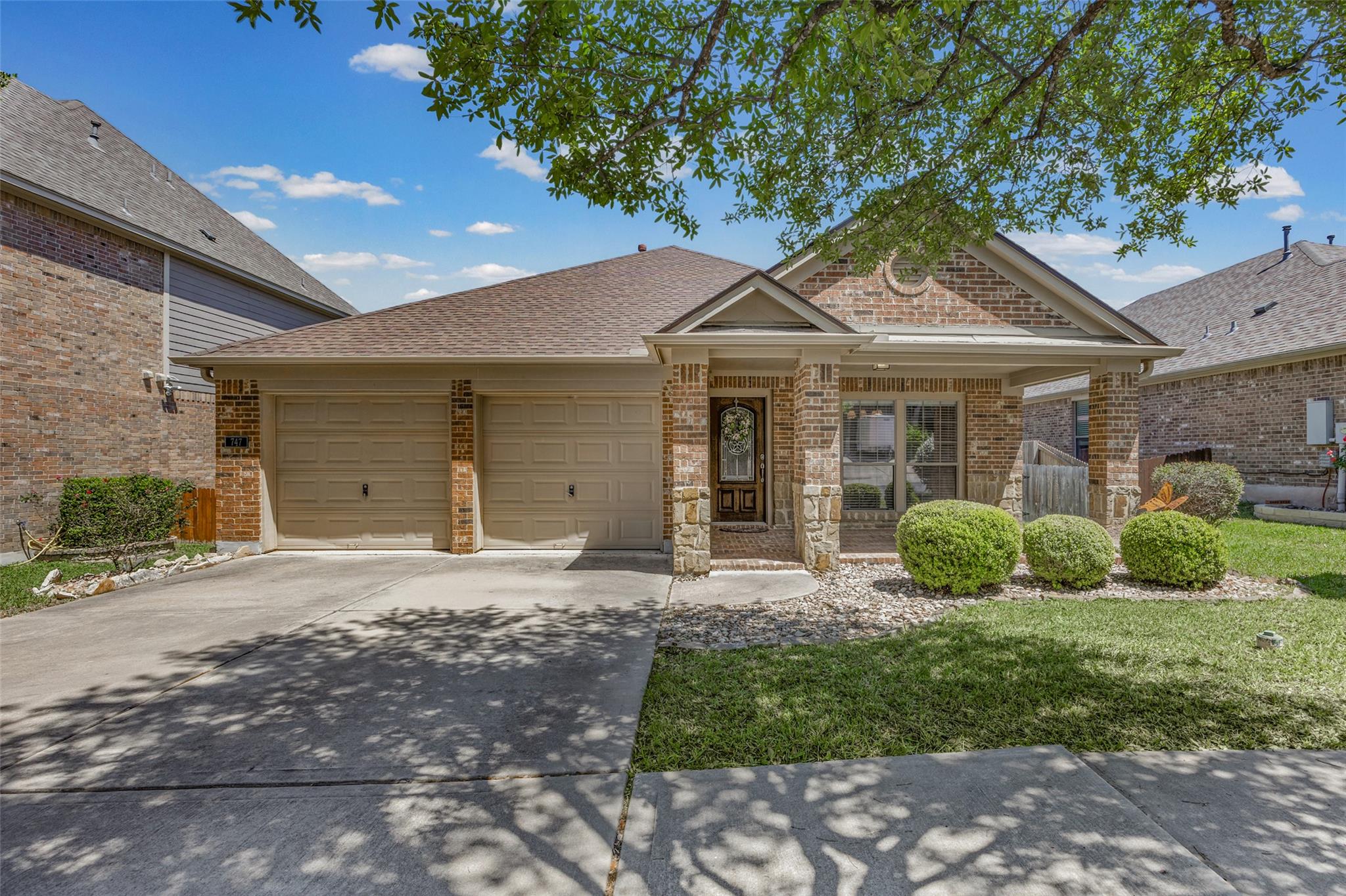 View of front facade featuring brick siding, a ga