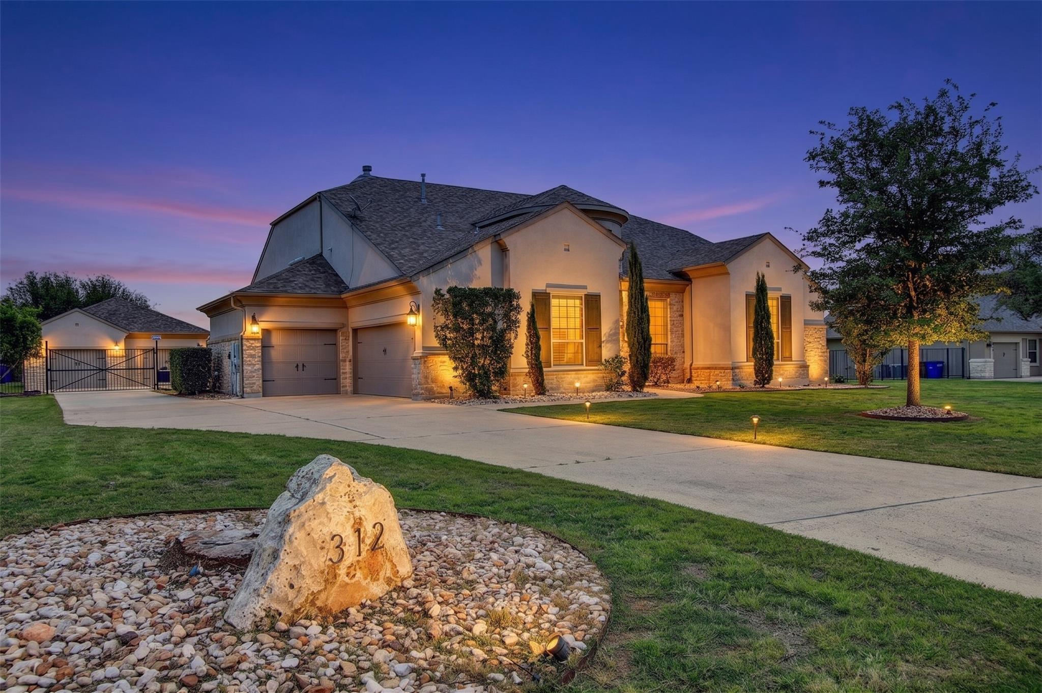 Stucco and stone exterior featuring a multi-car g