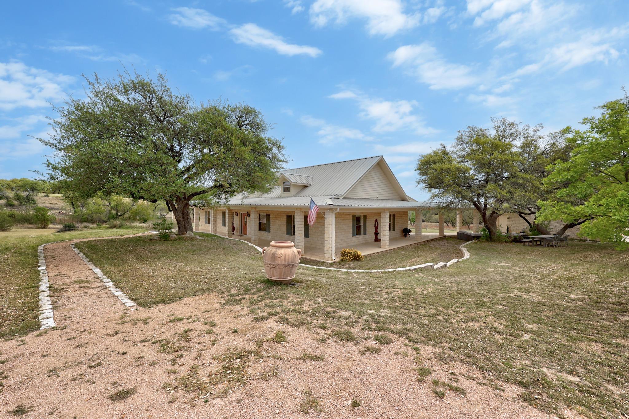 Rear view of house with covered porch, a metal ro