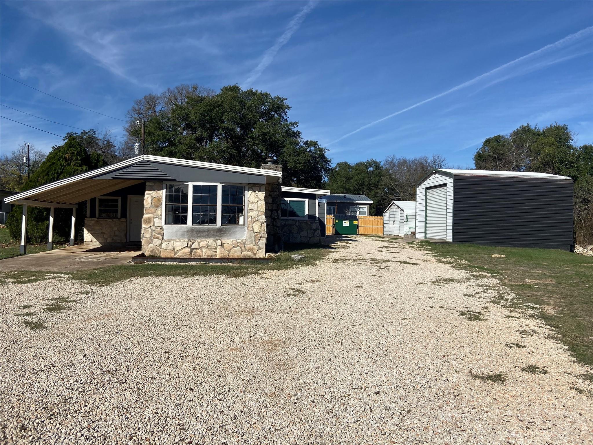View of side of property with stone siding, an ou