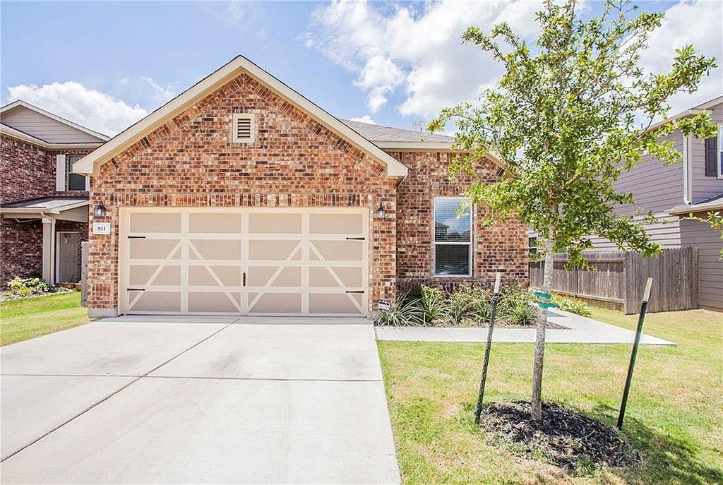 The property presents a brick facade, a two-car g
