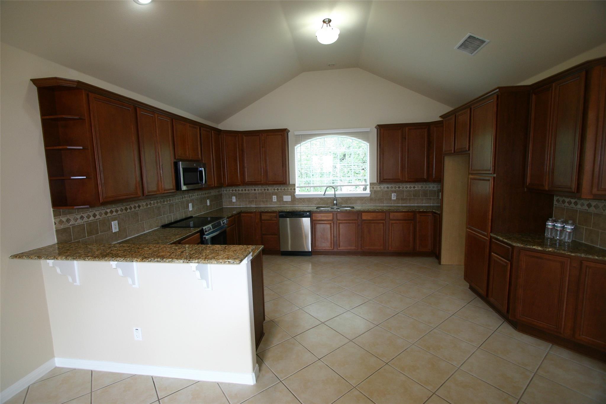 Kitchen featuring a peninsula, decorative backspl
