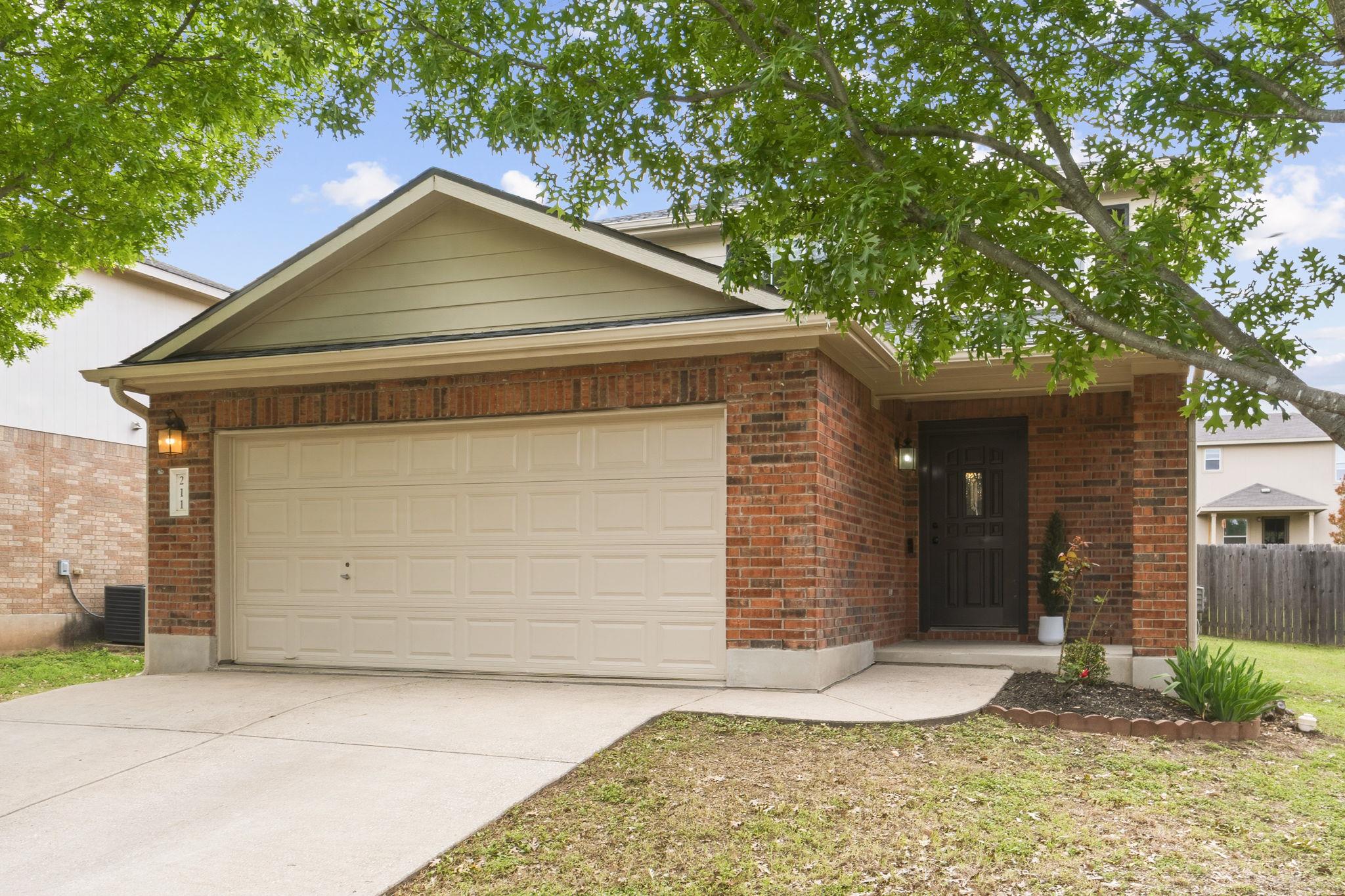 View of front of property featuring a garage, bri