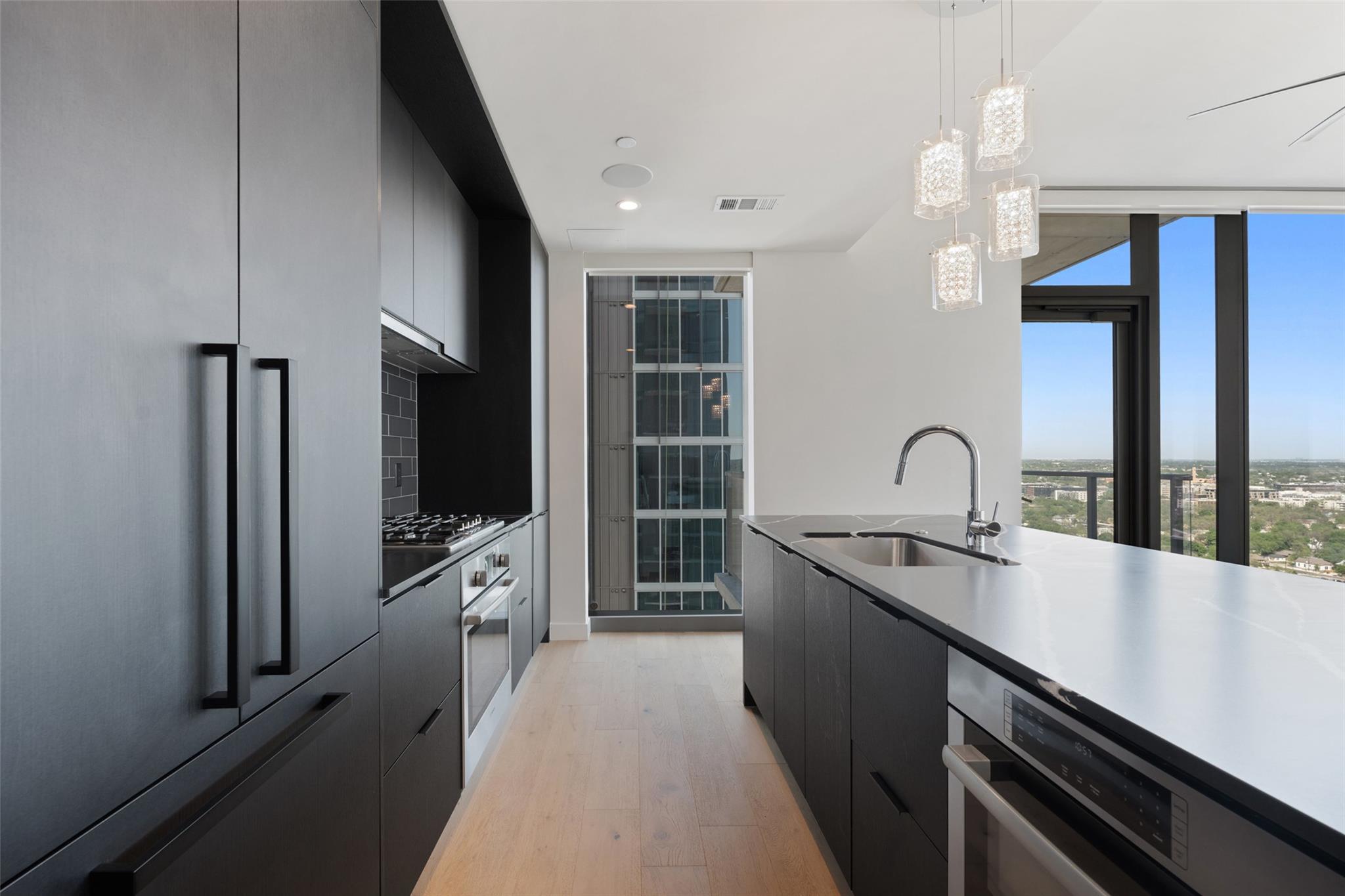 Kitchen with dark cabinetry, modern cabinets, sta