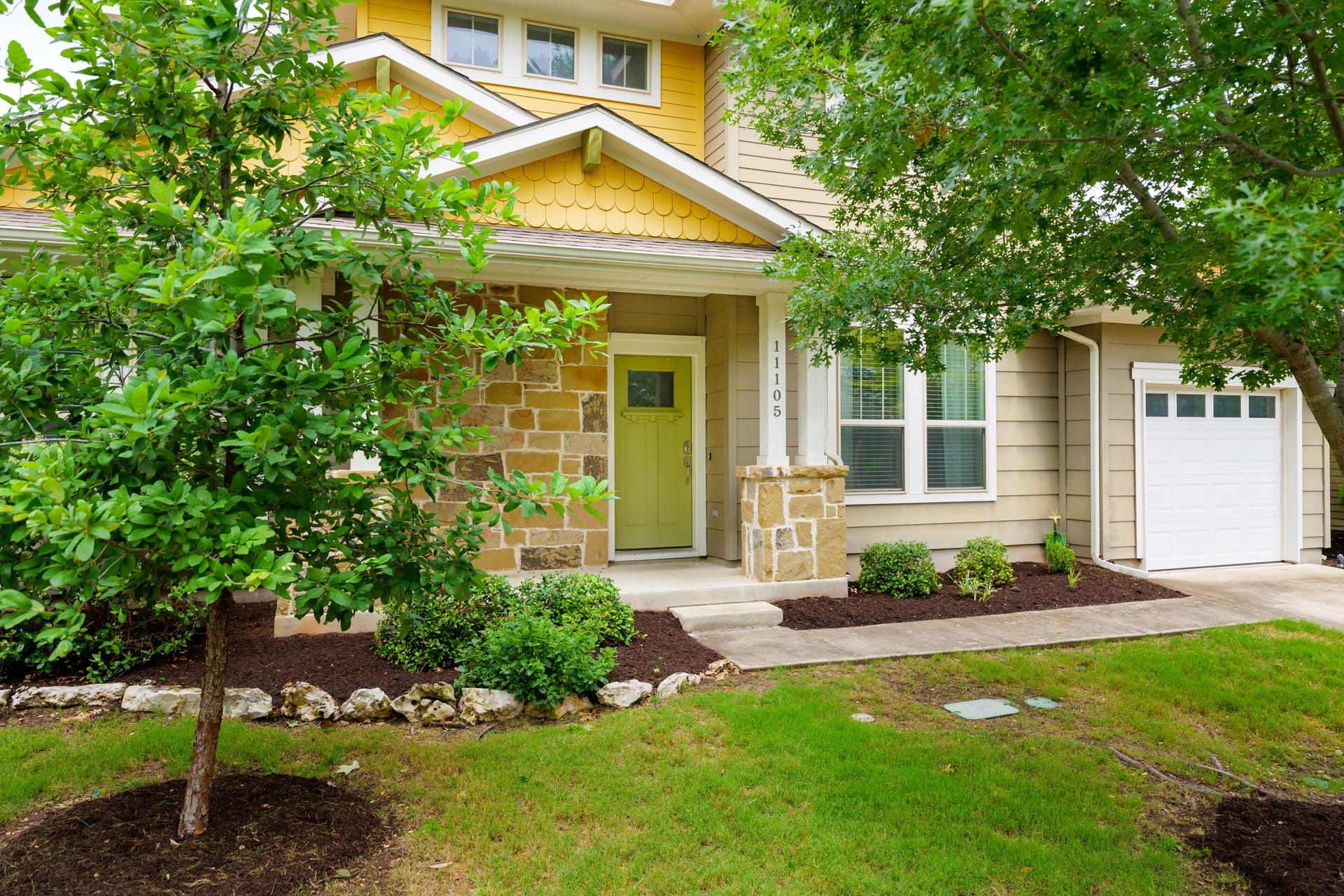 A welcoming front entrance, framed by lush greene