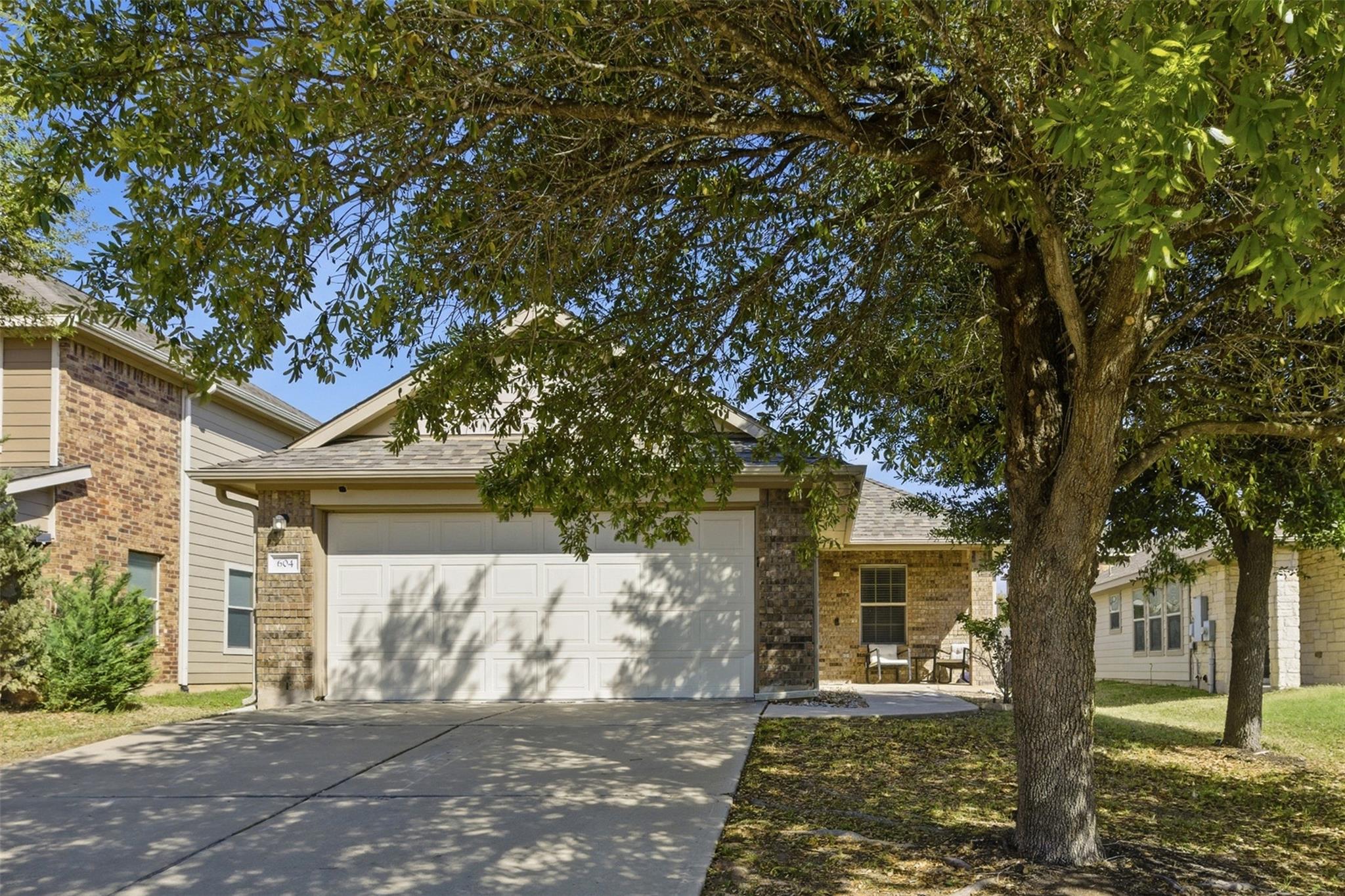 View of front facade with an attached garage, bri