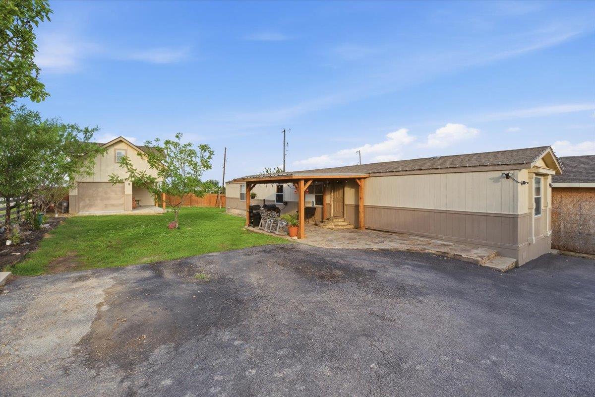 Property exterior featuring a carport with a wood