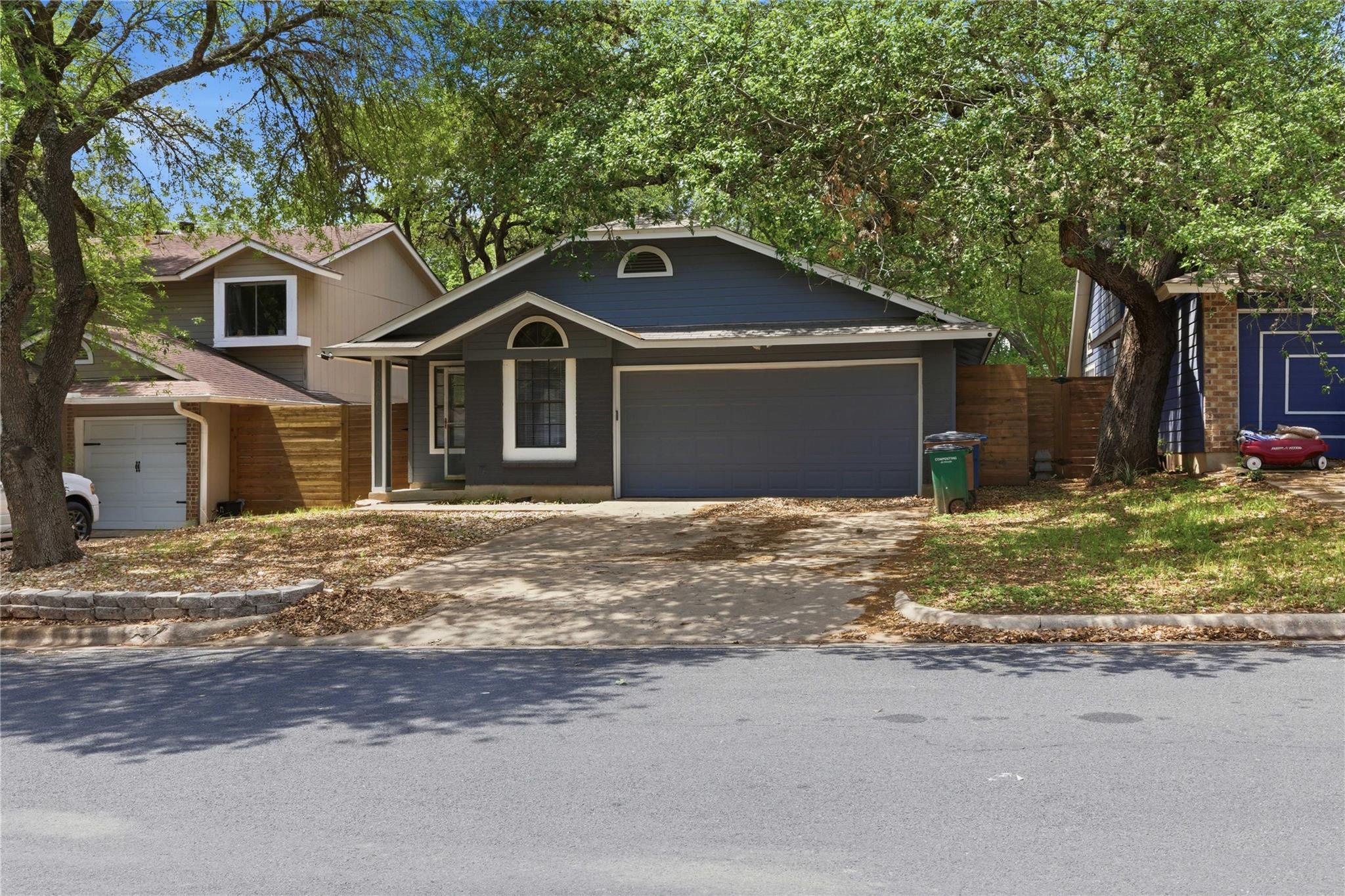 View of front facade featuring driveway and a gar