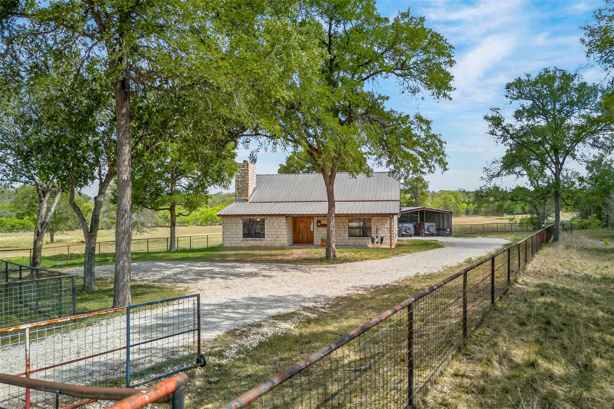 View of front of home with a chimney, a metal roo