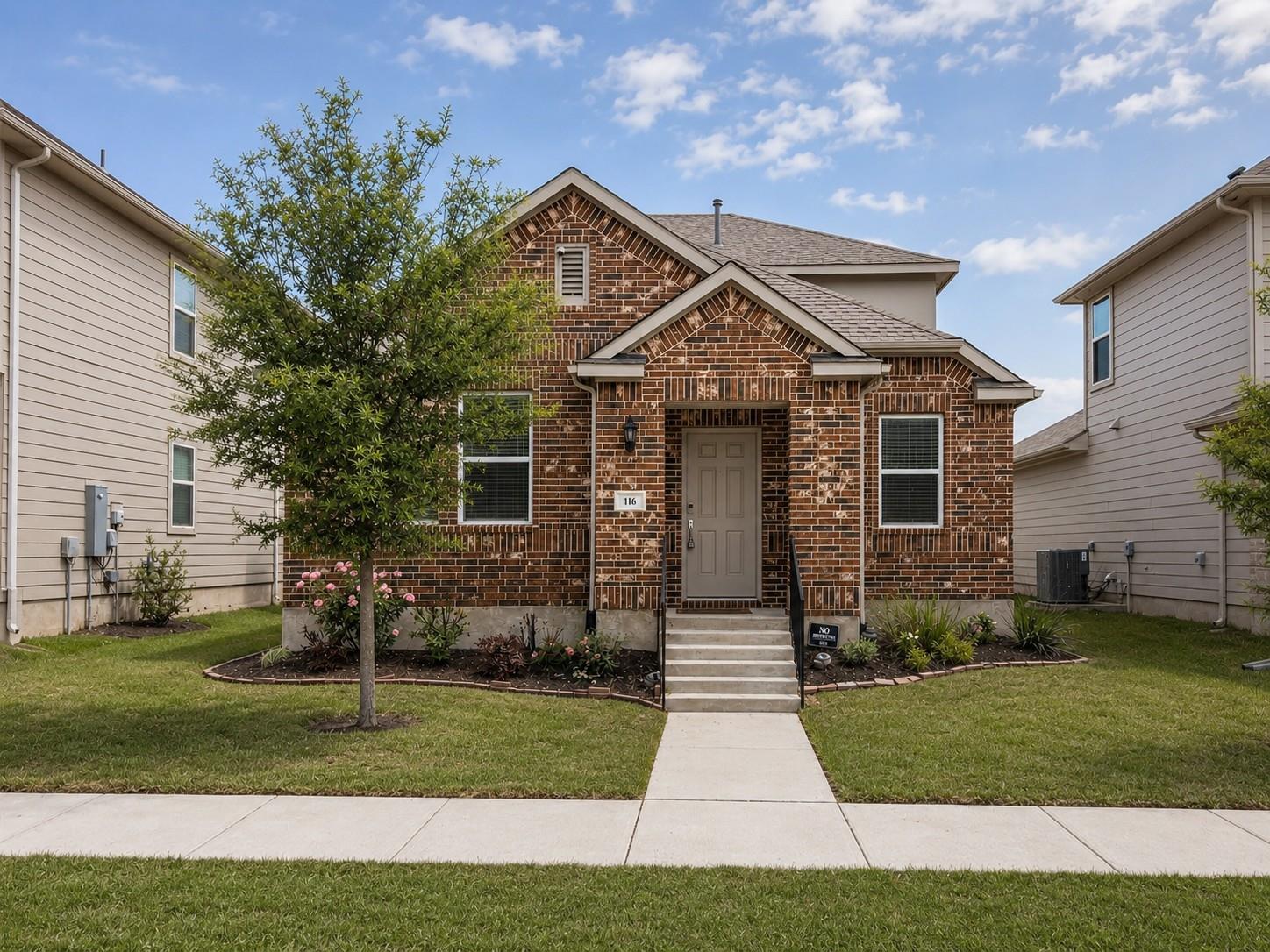 A classic brick facade and neatly kept lawn enhan