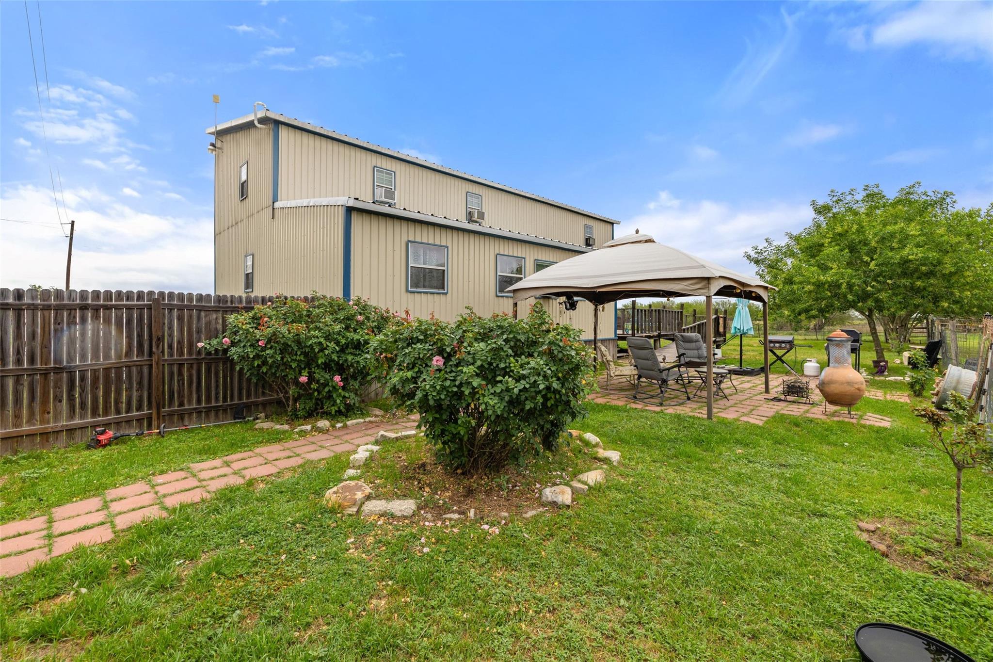 Back of house featuring a gazebo, a fenced backya