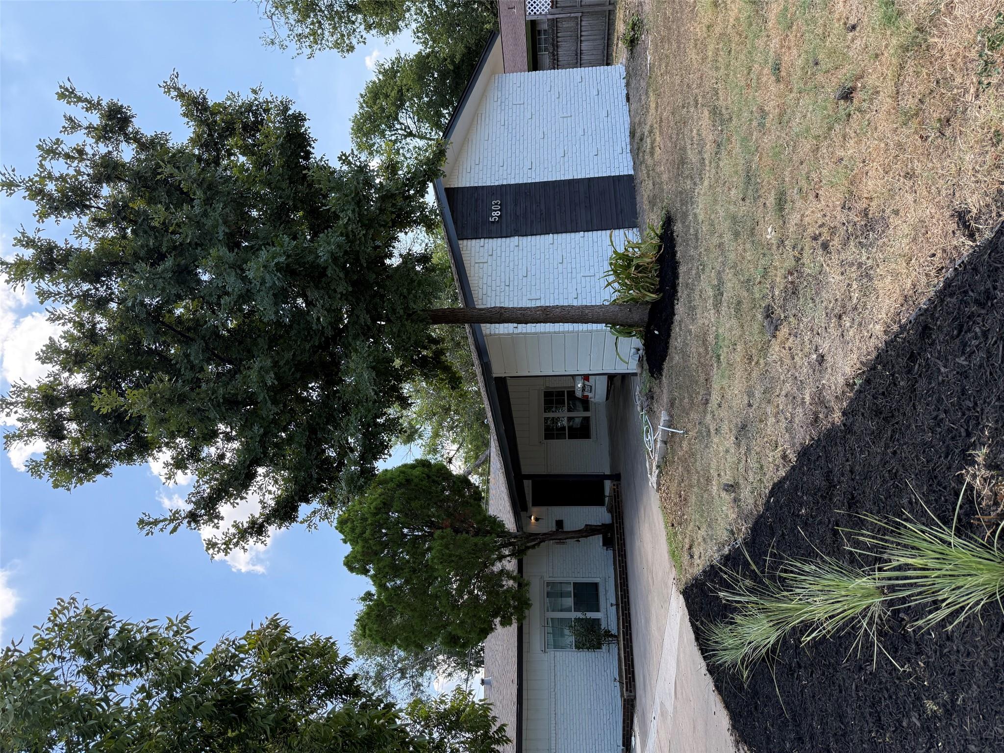 Mature trees shade the front lawn of this single-