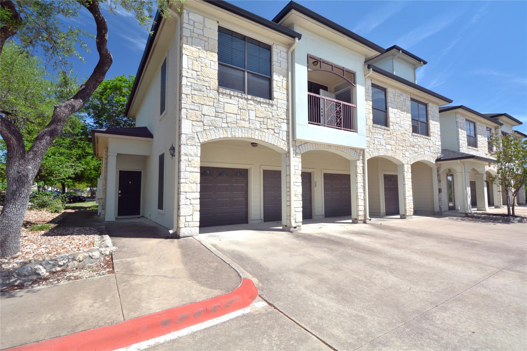 Multi-story property featuring a stone and stucco