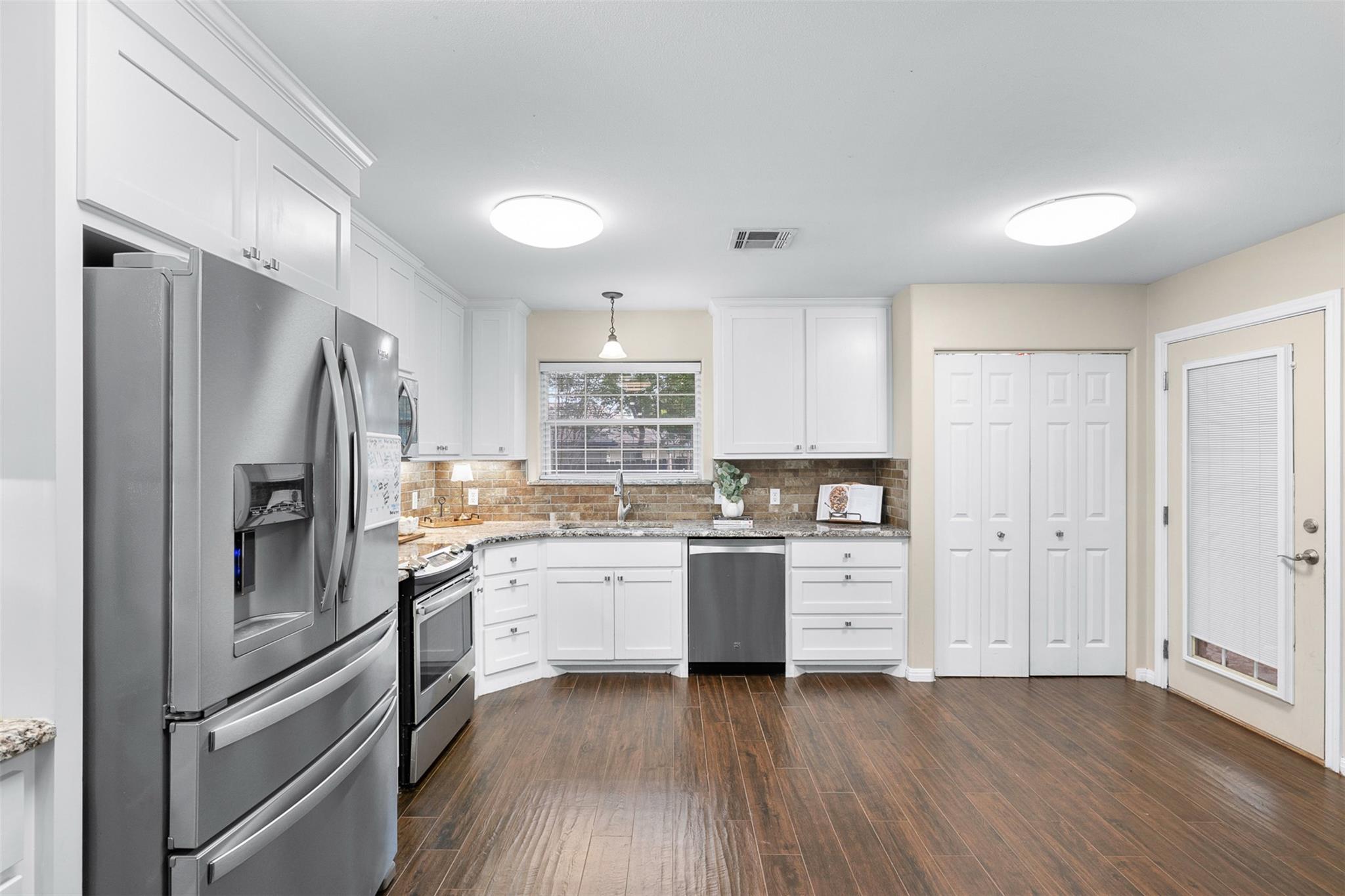 The well-appointed kitchen features white cabinet