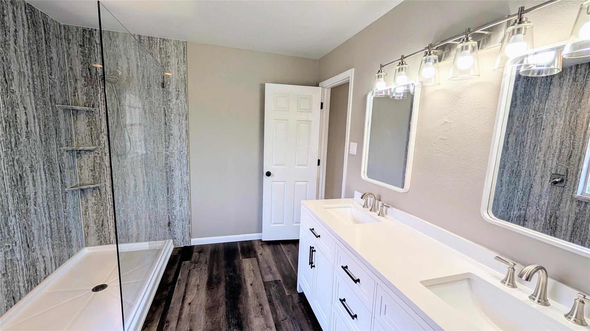 Full bath featuring a stall shower, dark wood fin