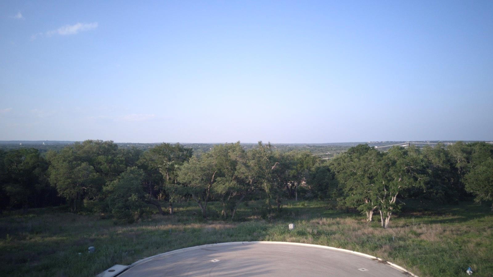 Expansive land parcel featuring mature trees, a c