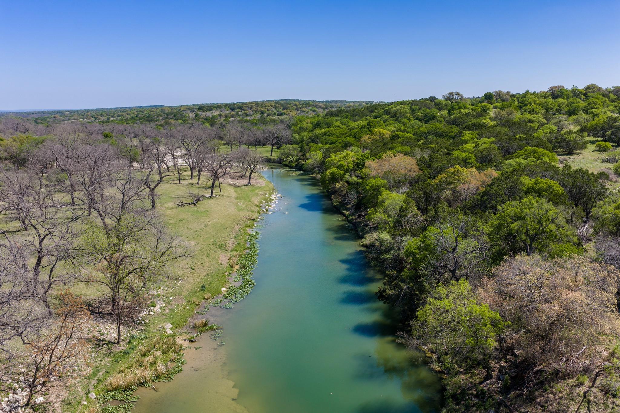 The property features a tranquil river with green