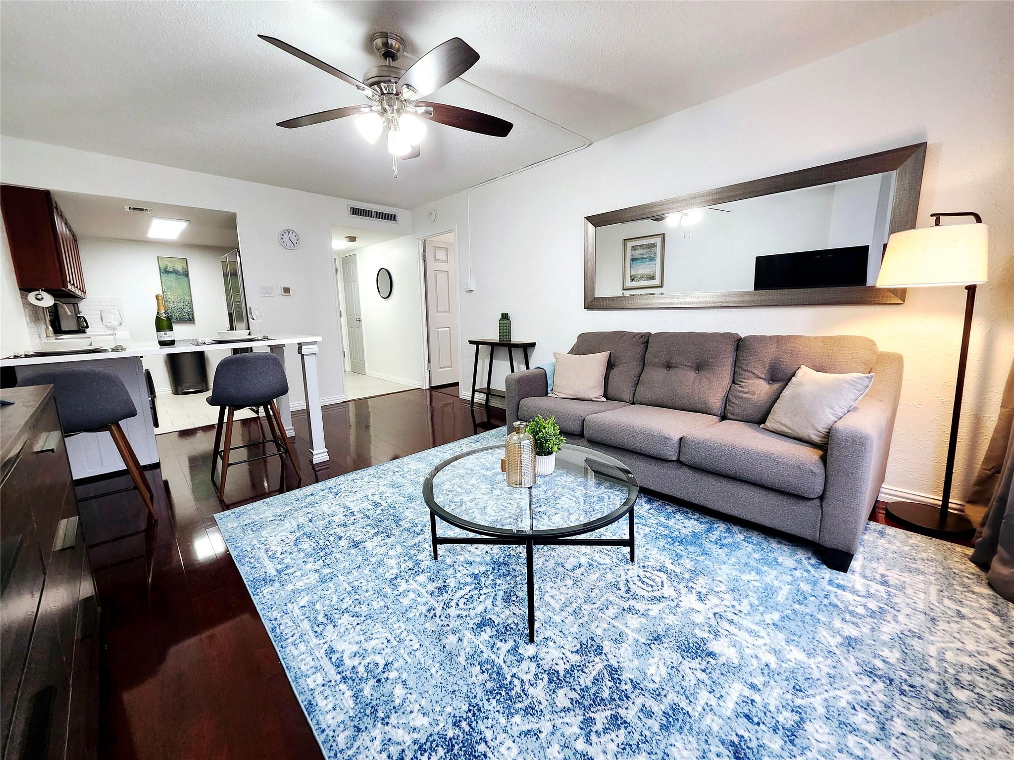 Living area featuring dark hardwood floors, a cei